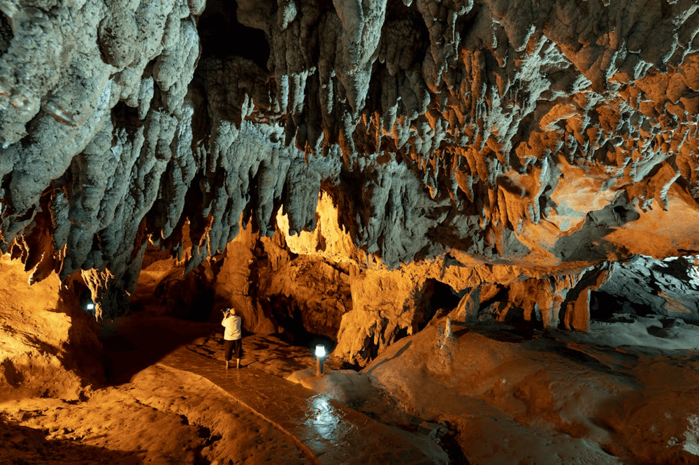 The cave lights cast a beautiful glow on the breathtaking stalactites (Source: Pexels)